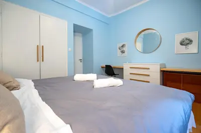 a blue bedroom with two white towels on a bed at Central Athens Apt Patio View by MPS in Athens