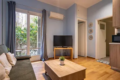 a living room with a couch and a tv at Central Athens Apt Patio View by MPS in Athens