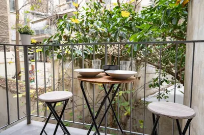 two bowls on a table on a balcony with two stools at Central Athens Apt Patio View by MPS in Athens