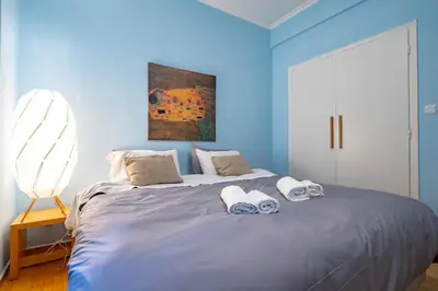 a blue bedroom with a bed with towels on it at Central Athens Apt Patio View by MPS in Athens