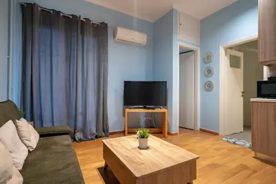 a living room with a couch and a tv at Central Athens Apt Patio View by MPS in Athens
