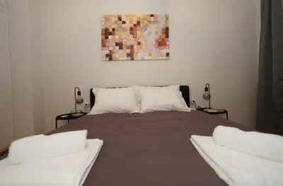 a bed with two pillows and a painting on the wall at Neos Kosmos Studio For 2 by MPS in Athens