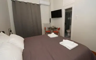 a bedroom with a bed with two towels on it at Neos Kosmos Studio For 2 by MPS in Athens