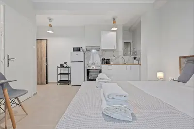 a white bedroom with two towels on a bed at Athens Urban Lifestyle Apartments in Athens