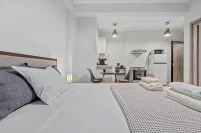 a bedroom with a white bed with towels on it at Athens Urban Lifestyle Apartments in Athens
