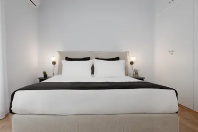 a bedroom with a large bed with white sheets and pillows at Acropolis Classy Apartments in Athens
