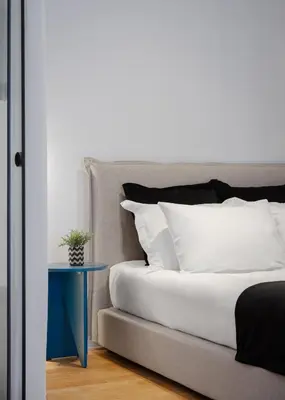 a bed with white pillows and a blue table at Acropolis Classy Apartments in Athens