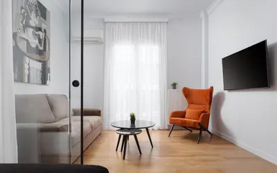 a living room with a couch and a table and a chair at Acropolis Classy Apartments in Athens