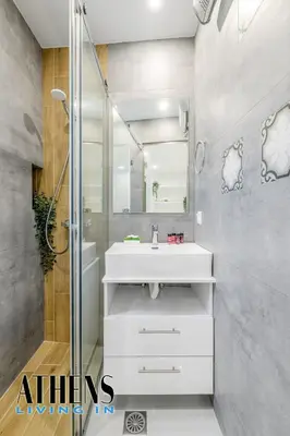 a bathroom with a white sink and a shower at Endless Blue Breathtaking View Apt 6fl 2&4ppl in Piraeus