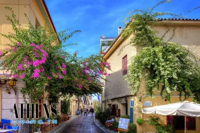 a narrow street with flowers hanging from buildings at Endless Blue Breathtaking View Apt 6fl 2&4ppl in Piraeus