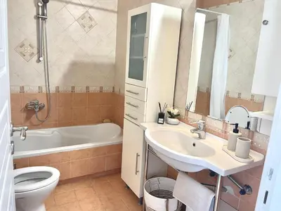 a bathroom with a sink and a toilet and a tub at Thalassea - Athenian Riviera in Athens
