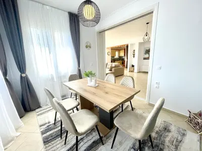 a dining room with a wooden table and chairs at Thalassea - Athenian Riviera in Athens