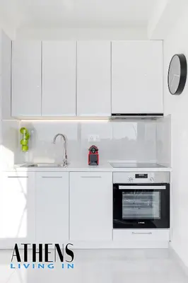 a white kitchen with a sink and a microwave at Endless Blue Breathtaking View Apt 7fl 2&4ppl in Piraeus