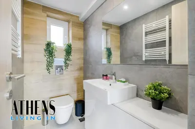 a bathroom with a sink and a toilet and a mirror at Endless Blue Breathtaking View Apt 7fl 2&4ppl in Piraeus