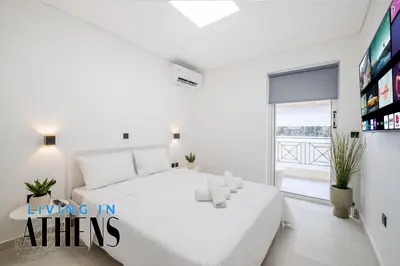 a white bedroom with a large white bed and a window at Athenian Exclusive residence 4&2 ppl in Athens