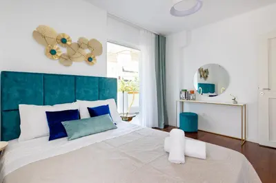 a bedroom with a large bed with a blue headboard at Peaceful apartment on the Athens Riviera in Athens