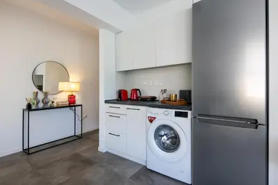 a kitchen with a washing machine and a sink at Peaceful apartment on the Athens Riviera in Athens