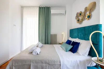 a bedroom with a large bed with two stuffed animals on it at Peaceful apartment on the Athens Riviera in Athens