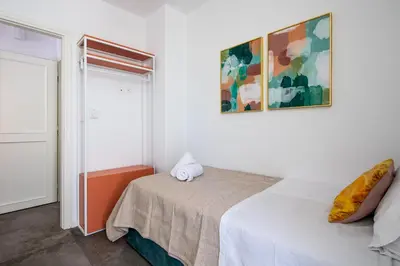 a white bedroom with a bed and a window at Peaceful apartment on the Athens Riviera in Athens
