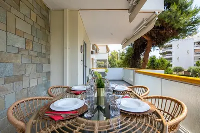 a table with chairs and plates on a balcony at Peaceful apartment on the Athens Riviera in Athens