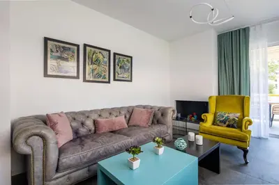 a living room with a couch and a yellow chair at Peaceful apartment on the Athens Riviera in Athens