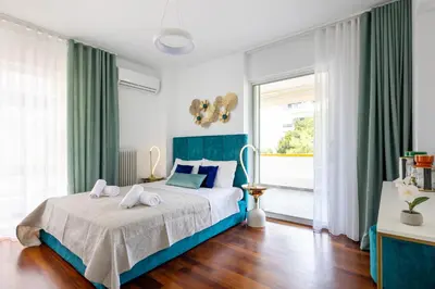 a bedroom with a blue bed and a window at Peaceful apartment on the Athens Riviera in Athens
