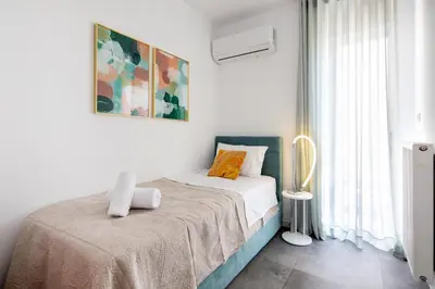 a white bedroom with a bed with a blanket at Peaceful apartment on the Athens Riviera in Athens