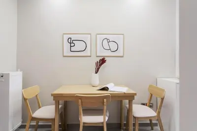 a dining room table with chairs and a vase on it at Tranquil Studio in Pangrati Athens Center in Athens