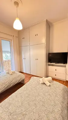 a bedroom with two beds and a flat screen tv at Fionas apartment in Athens in Athens