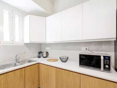 a kitchen with white cabinets and a microwave at Casa Divas Grand Palace Apartments in Athens
