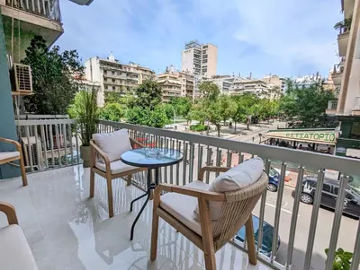 a balcony with a table and chairs and a view of a city at Casa Divas Grand Palace Apartments in Athens