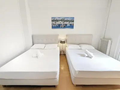 two beds in a small room with white sheets at Casa Divas Grand Palace Apartments in Athens