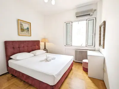 a bedroom with a large white bed with a red headboard at Casa Divas Grand Palace Apartments in Athens