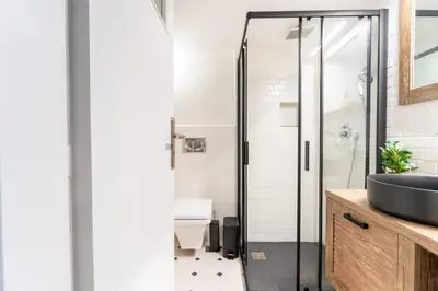 a bathroom with a glass shower and a sink at Rustic Whispers - close to Acropolis in Athens