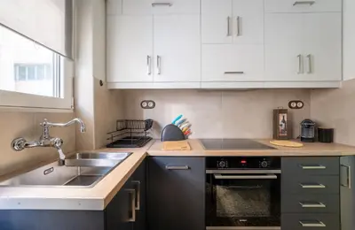 a kitchen with white cabinets and a sink at Rustic Whispers - close to Acropolis in Athens