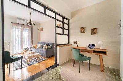 a living room with a desk with a laptop on it at Rustic Whispers - close to Acropolis in Athens