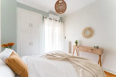a bedroom with white walls and a bed at Rustic Whispers - close to Acropolis in Athens