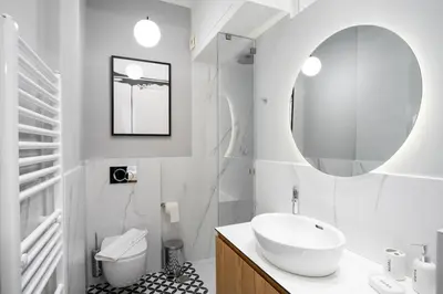 a white bathroom with a sink and a mirror at Kaplanon Residence Kolonaki in Athens