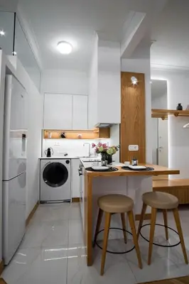 a kitchen with white cabinets and a counter with stools at Kaplanon Residence Kolonaki in Athens