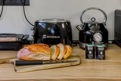 a loaf of bread on a cutting board next to a toaster at Callisto Elegant Apartment Near Acropolis in Athens