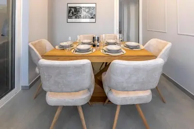a dining room table with four chairs and a wooden table at Callisto Elegant Apartment Near Acropolis in Athens
