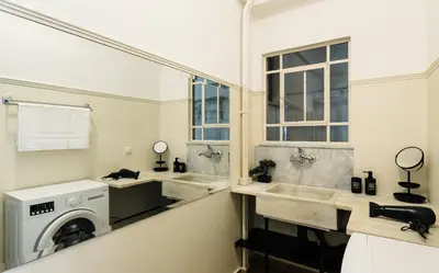 a bathroom with two sinks and a washing machine at Ideal escape for 2 in Athens