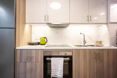 a kitchen with white cabinets and a sink at Loft 61 Charming renovated apartment with a loft! in Athens