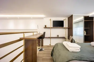 a bedroom with a bed and a desk and a television at Loft 61 Charming renovated apartment with a loft! in Athens