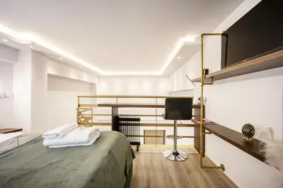 a bedroom with a bed and a desk and a chair at Loft 61 Charming renovated apartment with a loft! in Athens