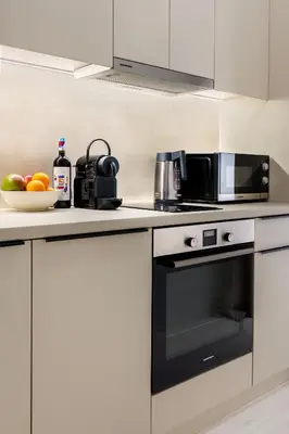 a kitchen with a black microwave and a bowl of fruit at Modern Designer Apartment in Athens Walk to Plaka & Acropolis in Athens