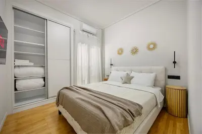 a white bedroom with a bed and a closet at Modern Designer Apartment in Athens Walk to Plaka & Acropolis in Athens