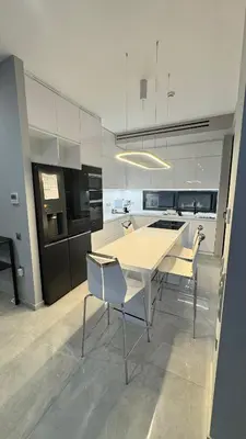 a white kitchen with a table and chairs in it at Oliva luxury apartment in Athens
