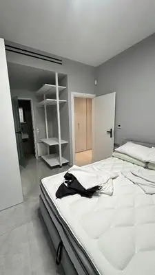 a large white bed with a black jacket on it at Oliva luxury apartment in Athens