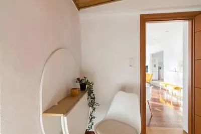 a room with a white chair and a mirror at Acropolis & Lycabetus View Helios Residence in Athens